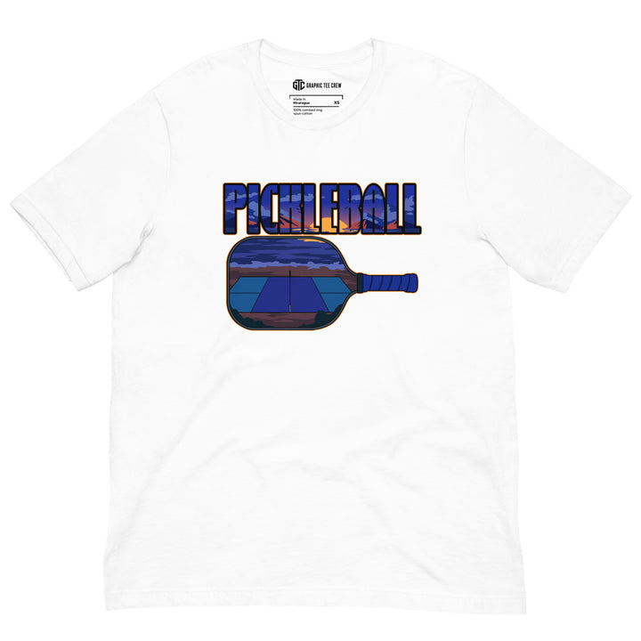 Sunset Court Pickleball T-Shirt featuring a mountain sunset and outdoor court inside bold pickleball lettering and a paddle graphic.